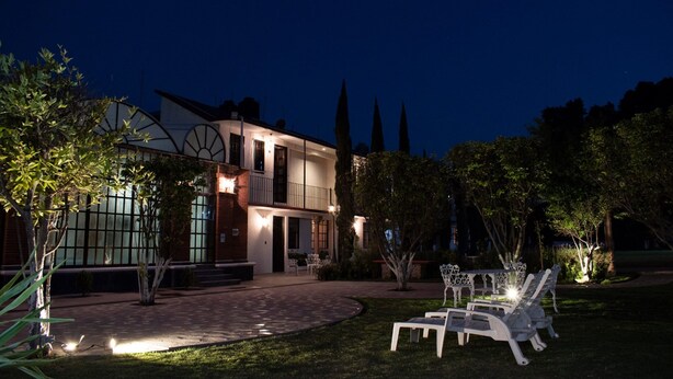 A modern two-story house with a well-lit entrance, a paved driveway, and outdoor seating area. - Hotel Real Campestre Tepetoci (Tepeji del Río de Ocampo)