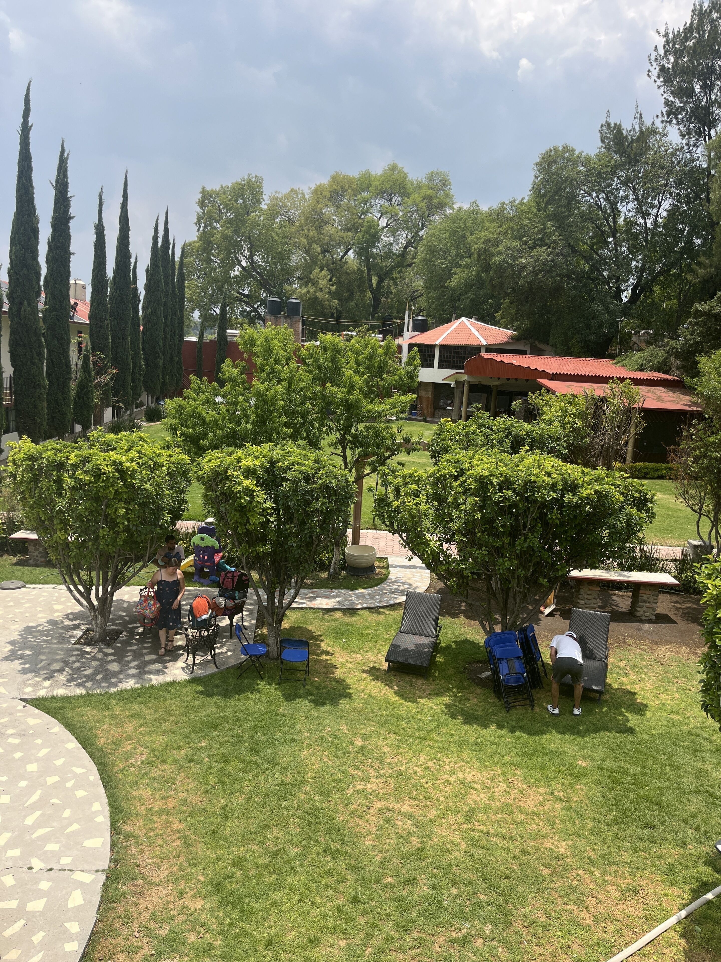 Un patio con mobiliario exterior, una chimenea y un banco de piedra.