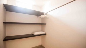 A narrow hallway with three dark wooden shelves against a white wall, one shelf has a white pillow. - DEPARTMENT FOR 5 PEOPLE. EXCELLENT LOCATION (Playa del Carmen)