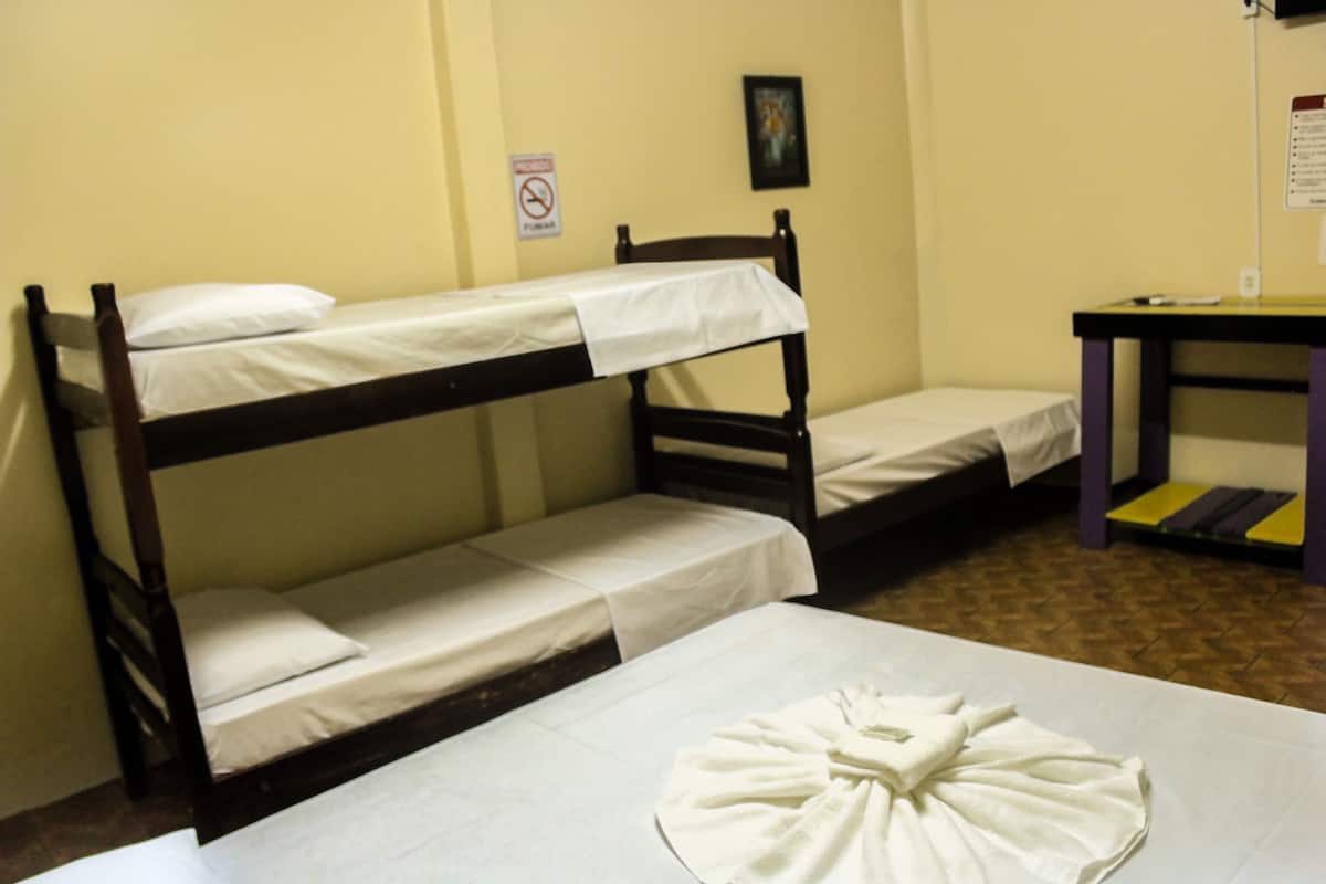 A bunk bed room with a table and a chair.