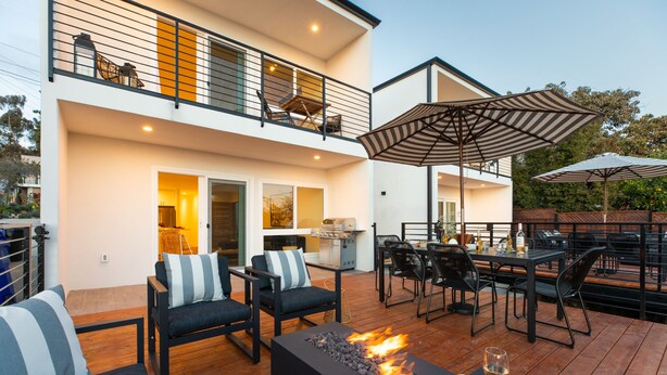 A modern outdoor patio with a fire feature, seating, and umbrellas. - Avalon 2 Unit Buyout (II & IV) by AvantStay | Mins to Gaslamp! Patio w/ BQQ (San Diego)