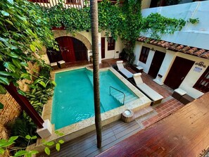 Una piscina al aire libre, tumbonas