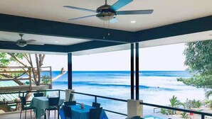 A restaurant with a view of the ocean, tables with blue tablecloths, and ceiling fans. - Bentrina Diving Resort (Mabini)