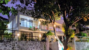 A two-story building with a stone wall, a staircase, and potted plants. - Bentrina Diving Resort (Mabini)
