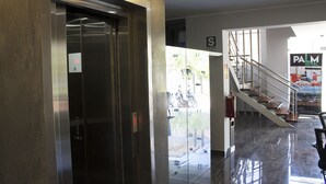 An elevator, a staircase, and a sign for the Palm Hotel. - Palm Hotel (Tarapoto)