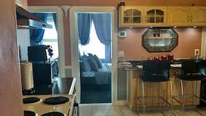 A compact kitchen with a stove, cabinets, and a dining area with chairs. - Well-appointed with everything needed (Pawtucket)