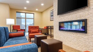 A modern hotel lobby with a large seating area, a flat-screen TV, and a fireplace. - Comfort Inn & Suites (Goderich)