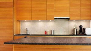 Eine moderne Küche mit Holzschränken, einer Granit-Arbeitsplatte und Standardgeräten.