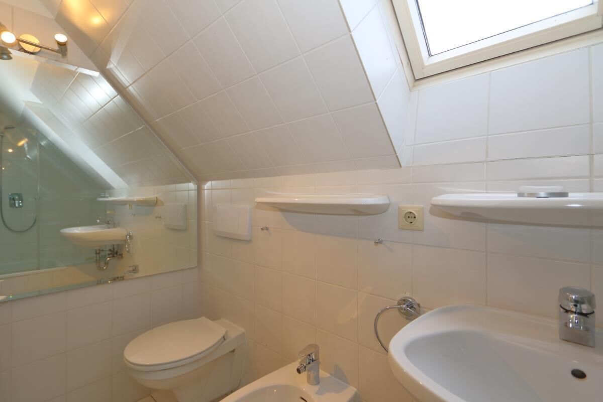 Ein modernes Badezimmer mit Toilette, Bidet und Waschbecken.