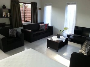 Bangalô com design assinado, vista para o jardim | Área de estar | TV de tela plana, DVD player