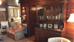 A cozy living room with a fireplace, a bookshelf, and a comfortable seating area. - Cottage:  3005 Palmetto Blvd. (Edisto Beach)
