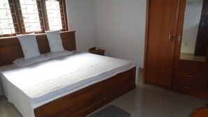 A bedroom with a wooden bed, a nightstand, a wardrobe, and a window with blinds. - 1 and 1 (Malimbada)