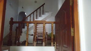 A wooden staircase with a handrail leading to a landing. - 1 and 1 (Malimbada)