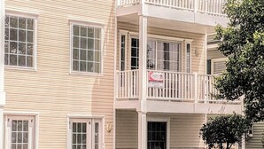 Un immeuble à plusieurs étages, doté d’une façade symétrique, de grandes fenêtres et d’un balcon situé au dernier étage.
