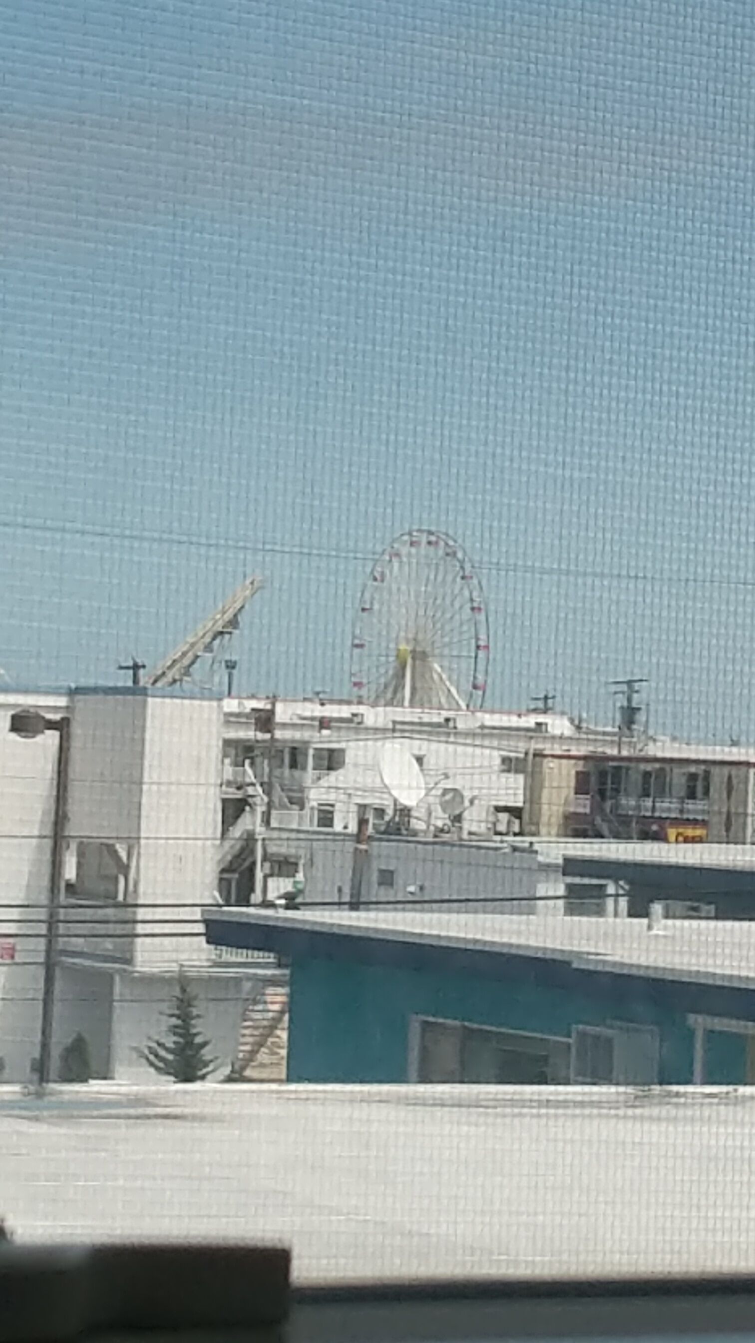 Un edificio con una noria grande al fondo.