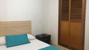 Ein Schlafzimmer mit einem Bett, einem Nachttisch und einem Holzschrank.