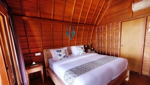 Quarto de madeira com cama, mesa de cabeceira e guarda-roupa.