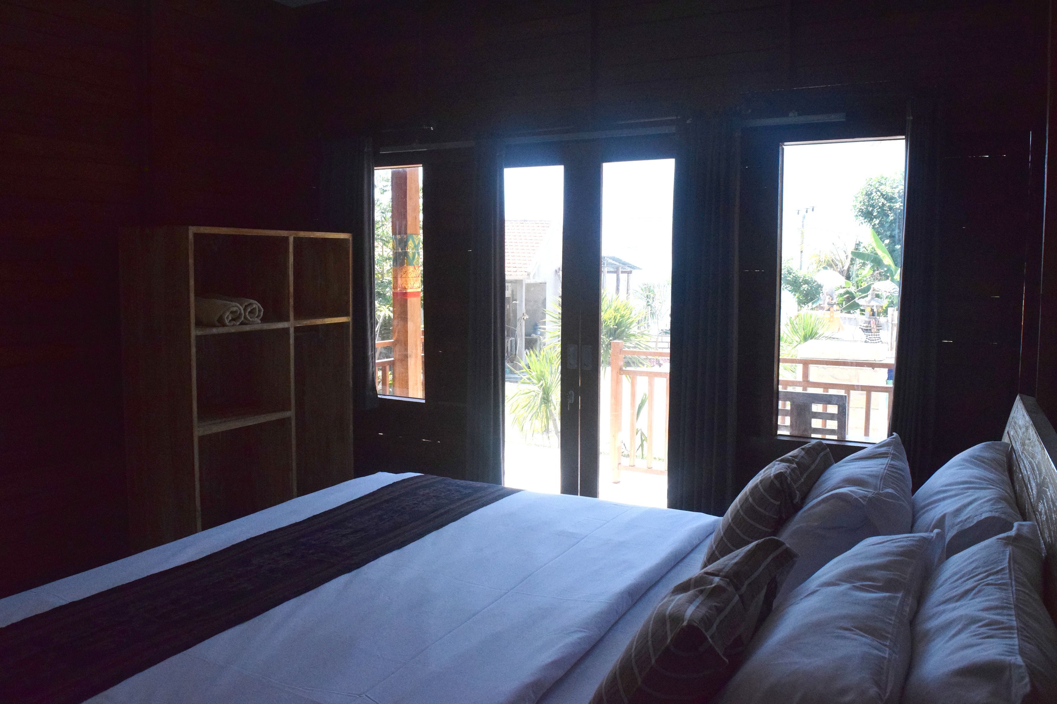 Une chambre à coucher avec un lit, une armoire en bois et une vue sur l’extérieur.