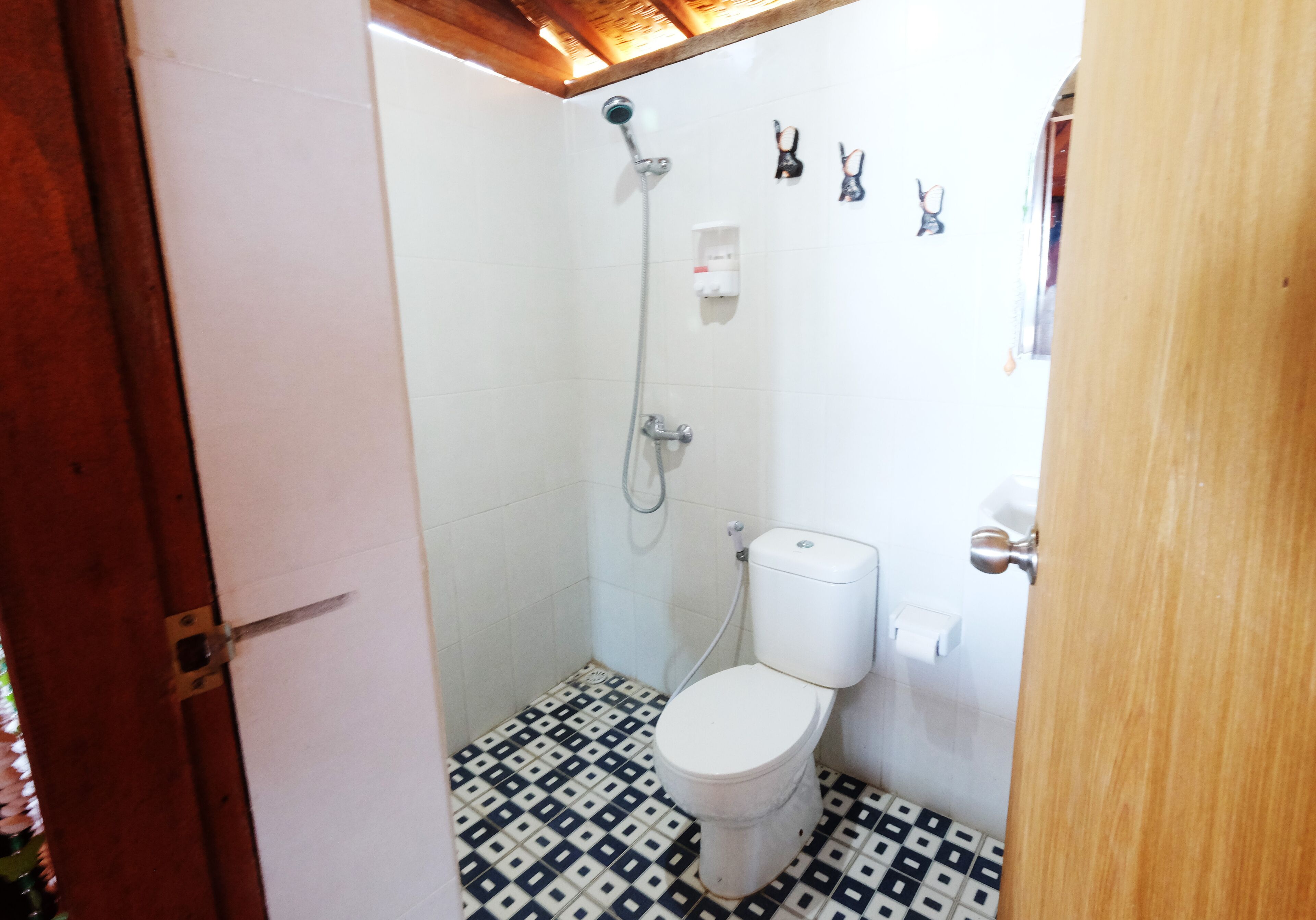 A small bathroom with a toilet, shower, and tiled floor.