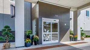 A modern building entrance with a glass door, numbered 520, and potted plants. - Sleep Inn Great Falls Airport (Great Falls)