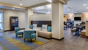 A hotel lobby with a seating area, a reception desk, and a dining area. - Sleep Inn Great Falls Airport (Great Falls)