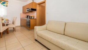 A compact living space with a kitchenette, a dining area, and a sofa.