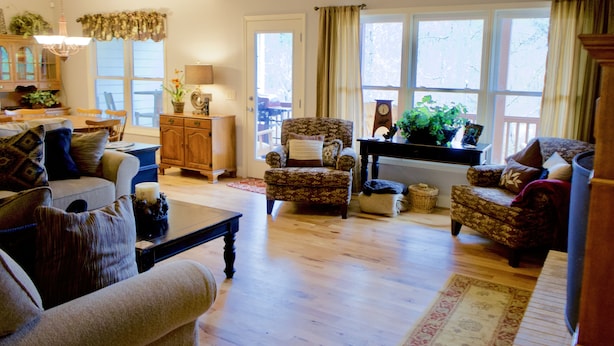 A cozy living room with a sofa, armchairs, a coffee table, and a dining area with a wooden cabinet and chandelier. - Explore, Relax: Mountain House, Yahoola Creek, Cherokee Forest (Dahlonega)
