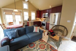 A living room with a sofa, a patterned rug, and a wicker chair. - The Alley House, LOCATION! 1/2 block to Elk Ave (Crested Butte)
