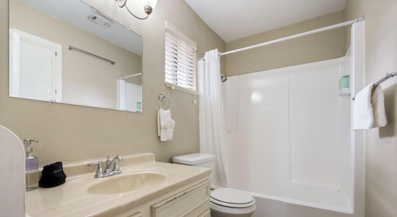 A bathroom with a sink, toilet, and shower.