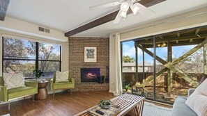 A spacious living room with a fireplace, large windows, and a view of the outdoors. - HC #212 xxxxxxxxxxxx (Austin)