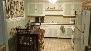 A compact kitchen with a dining area, a refrigerator, and a microwave. - Rustic Hideaway -pets welcome, downtown- (Idaho Falls)