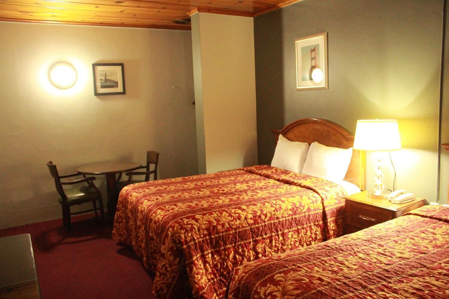 A hotel room with two beds, a desk, and a chair.