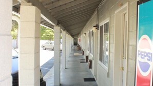 A motel corridor with a covered walkway, individual rooms, and a Pepsi sign. - Budget Inn Yreka (Yreka)