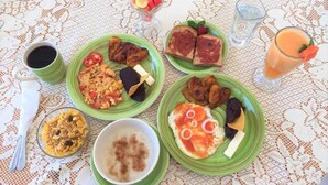 A table with various breakfast items including toast, eggs, and fruit. - Lauris Hotel (San Agustin Lanquin)
