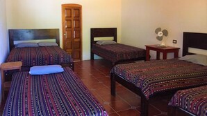A room with four beds, a wooden wardrobe, a fan, and a light fixture. - Lauris Hotel (San Agustin Lanquin)