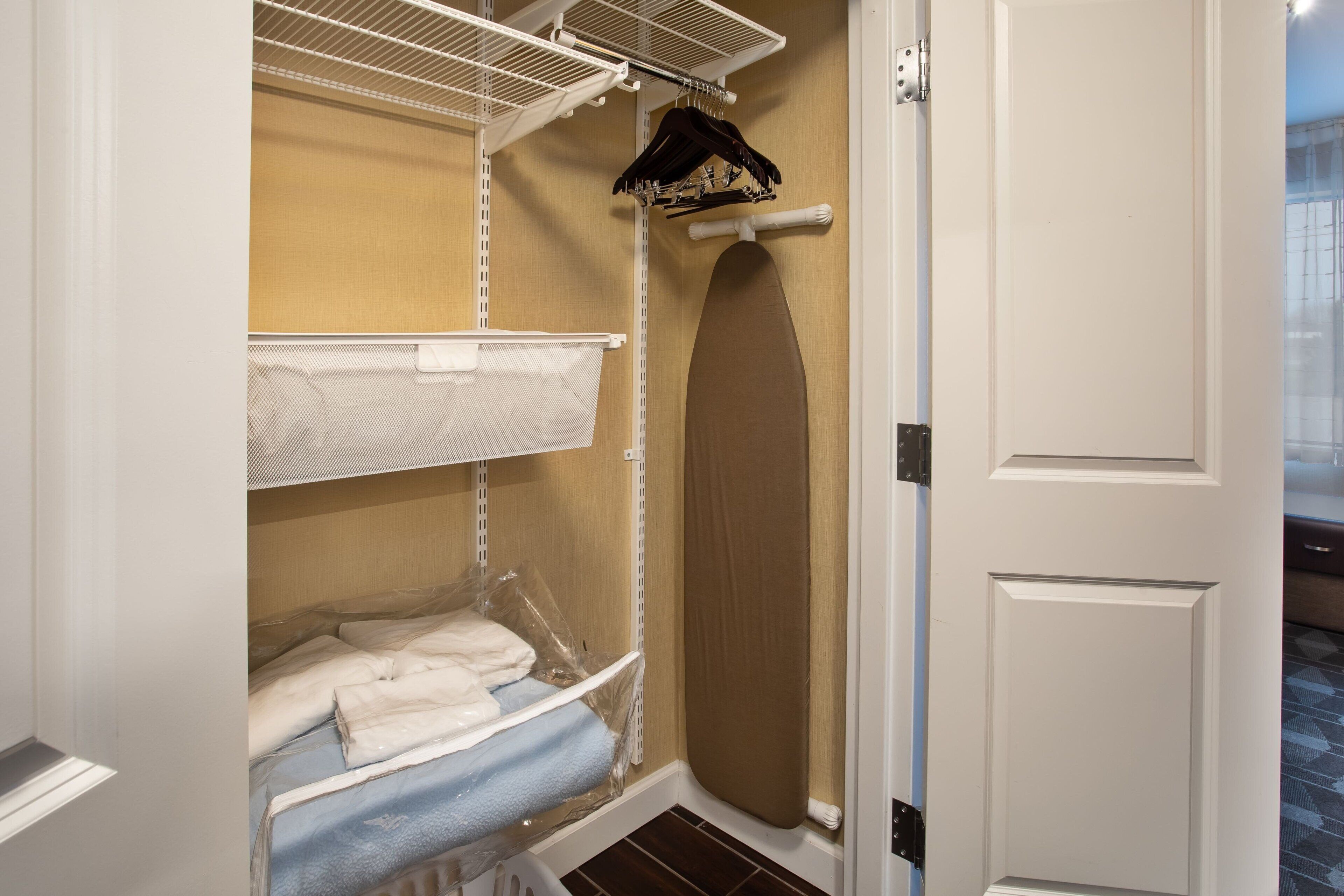 A walk-in closet with metal shelving, a hanging rack, and a large mirror.