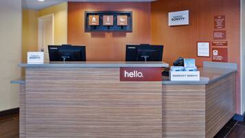 A reception desk with a 'hello.' sign, Lenovo computers, and a 'MARRIOTT BONVOY' sign.