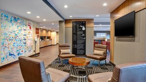 Um hall com poltronas de couro, um espaço para café, um mapa e um aviso com os serviços disponíveis.