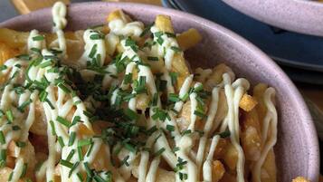 Eine Schüssel Pommes Frites mit Käse und Schnittlauch.