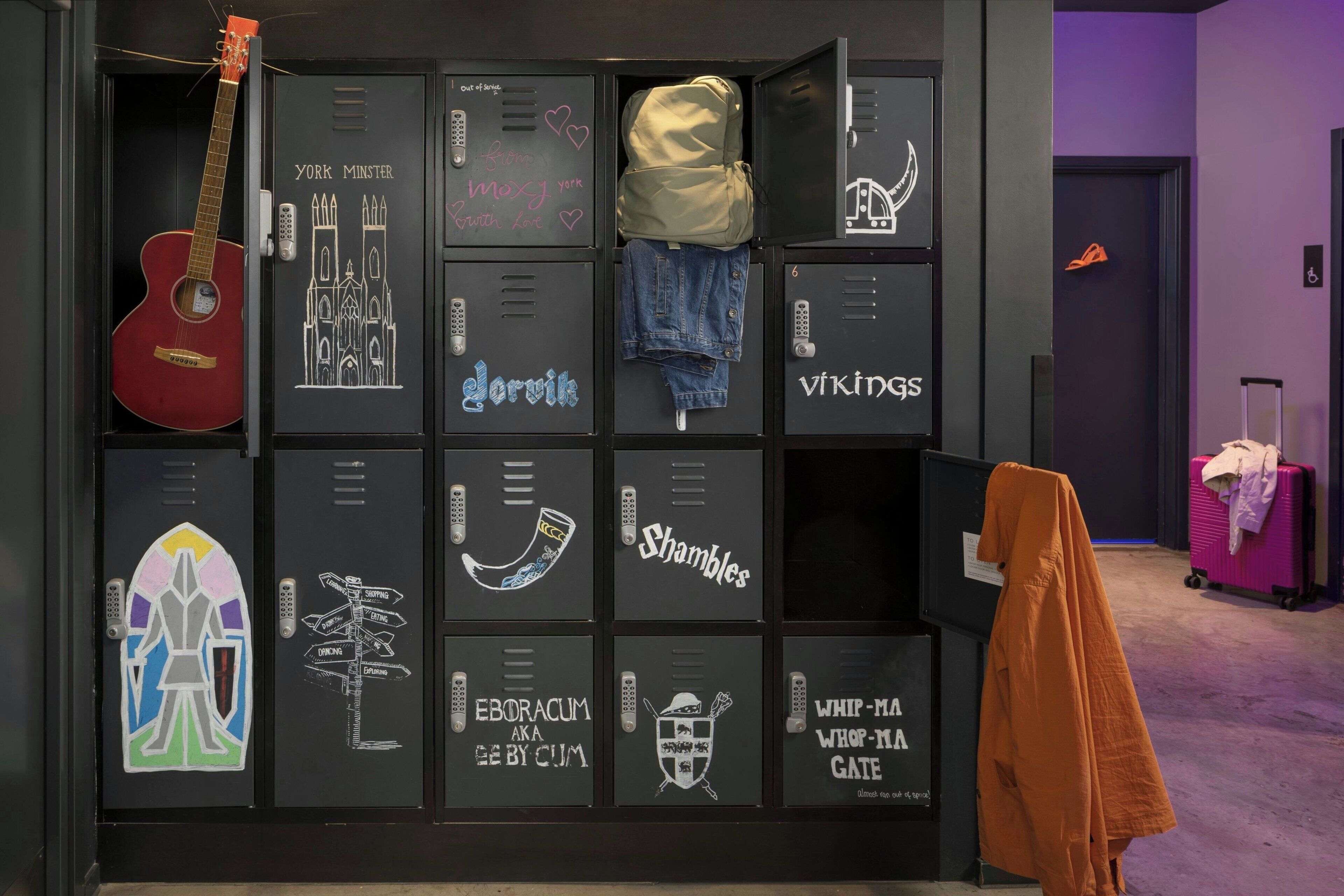 A wall of lockers with various items like a guitar, jeans, and a backpack.