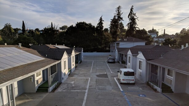 A row of single-story buildings with a parking lot in front.