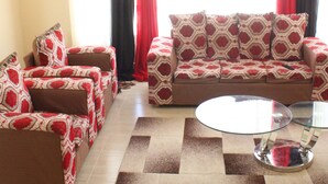 A living room with a sofa set, a coffee table, and a patterned rug. - 254 Airport Inn (Syokimau)