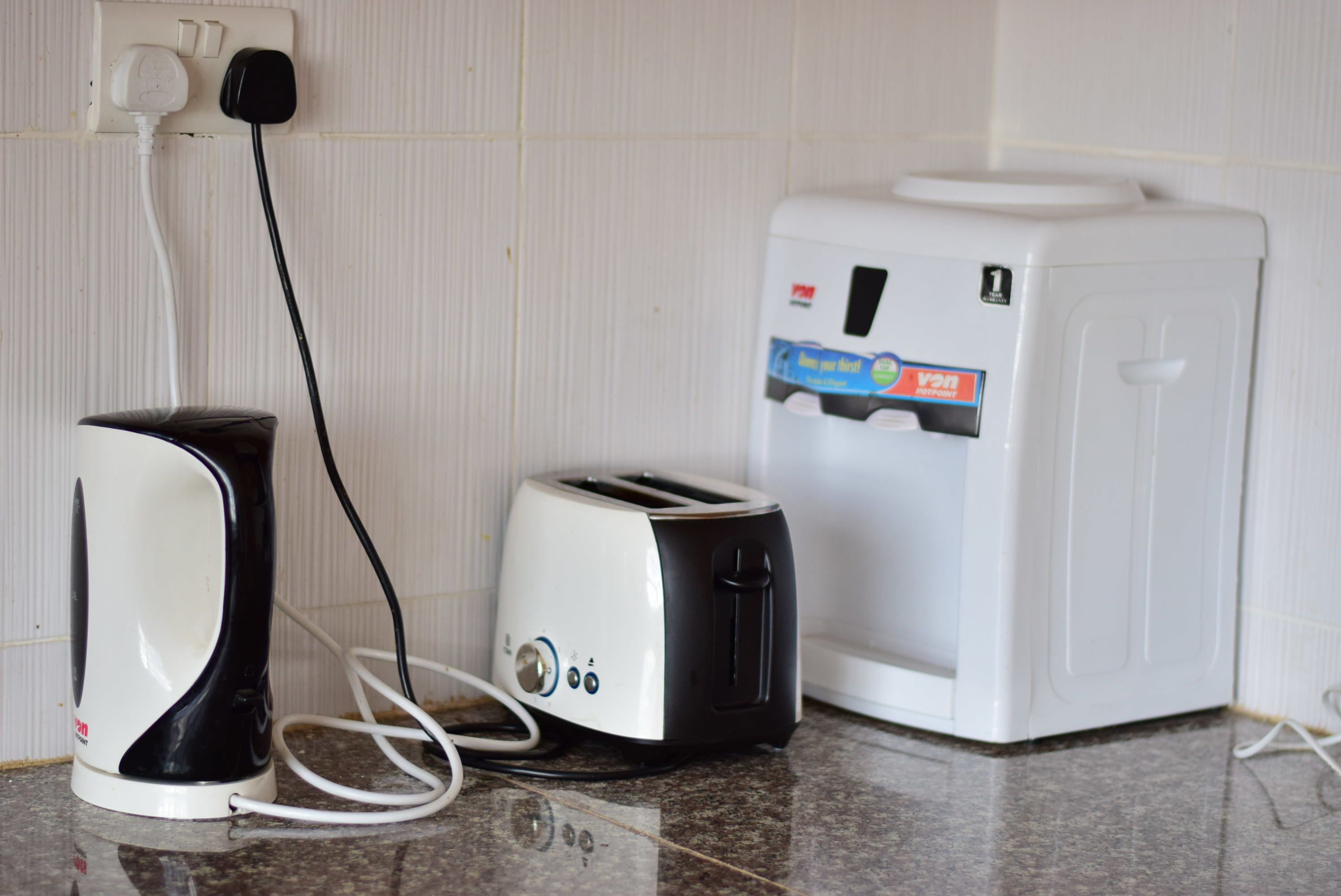 A kitchen with a toaster, a kettle, and a microwave.