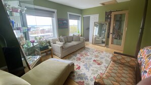 A living room with a sofa, a coffee table, and a glass cabinet with decorative items.