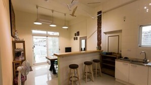 A modern kitchen with a central island, bar stools, and a window providing natural light. - Pang Mi B&B (Taitung)