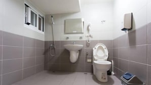 A small bathroom with a toilet, sink, and shower. - Pang Mi B&B (Taitung)