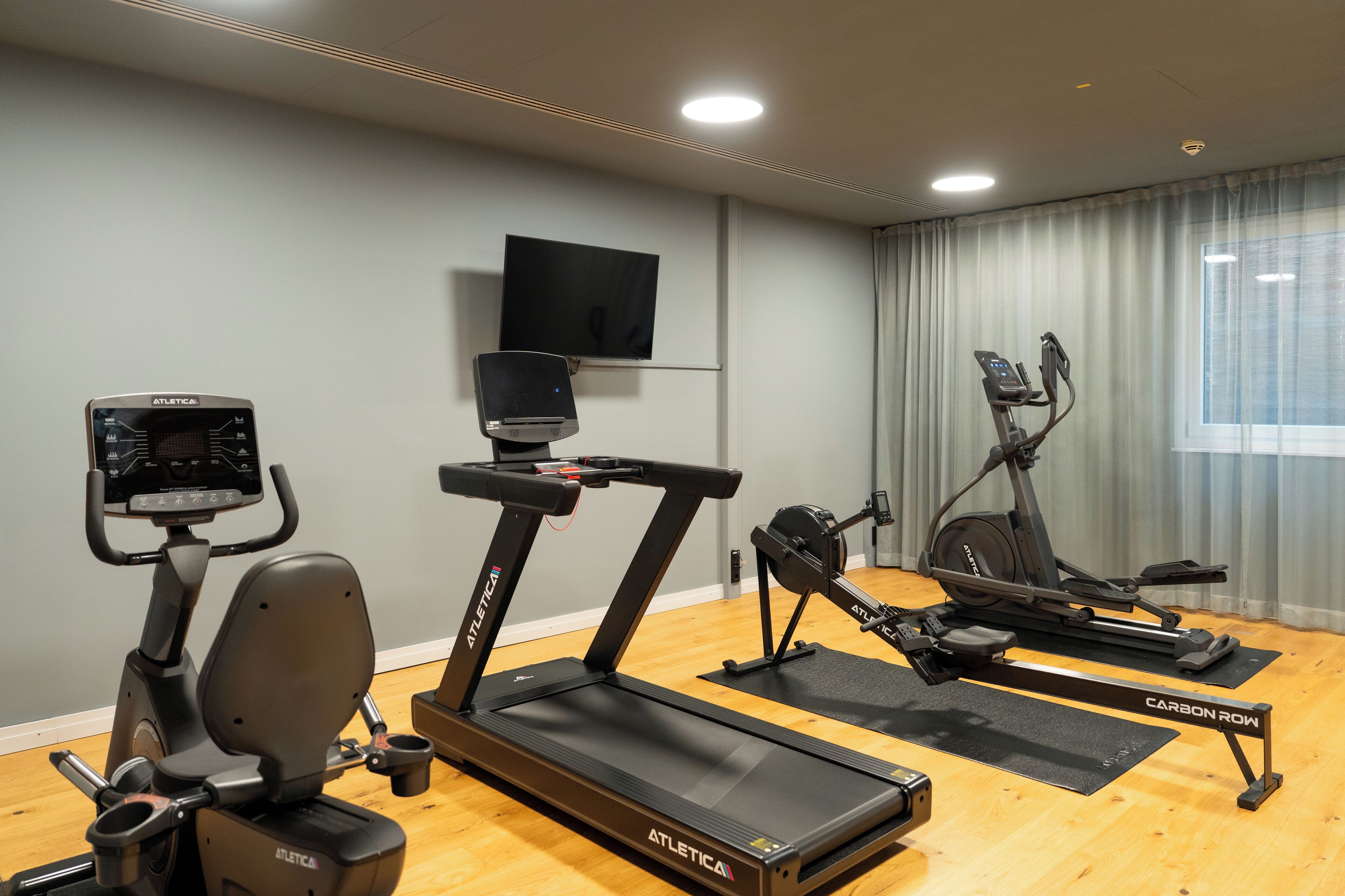 A home gym with an elliptical, a stationary bike, and a treadmill.