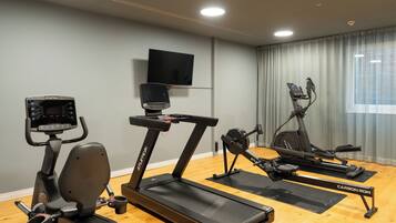 A home gym with an elliptical, a stationary bike, and a treadmill.