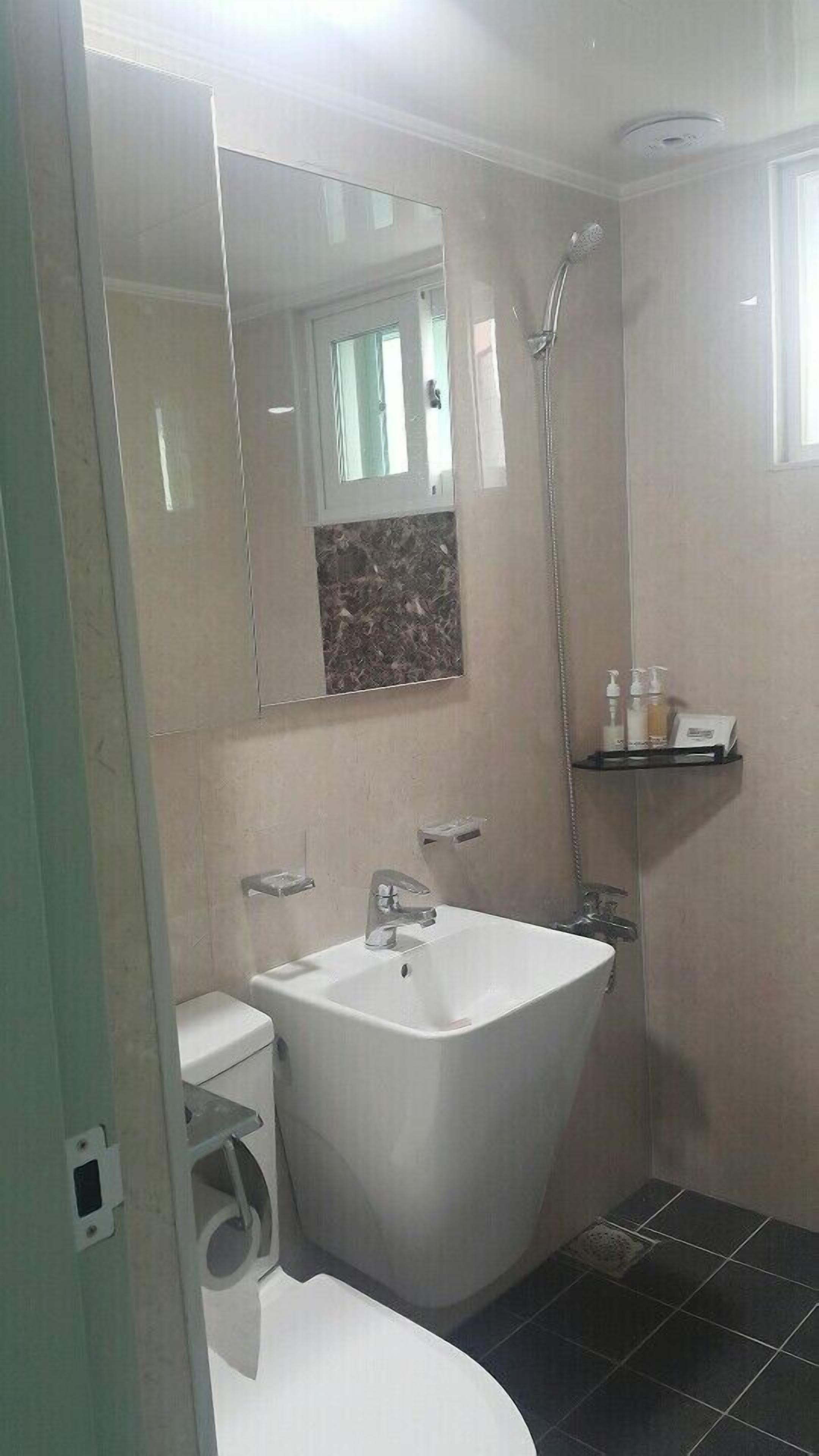 A bathroom with a freestanding bathtub, a toilet, a sink, and a shower.