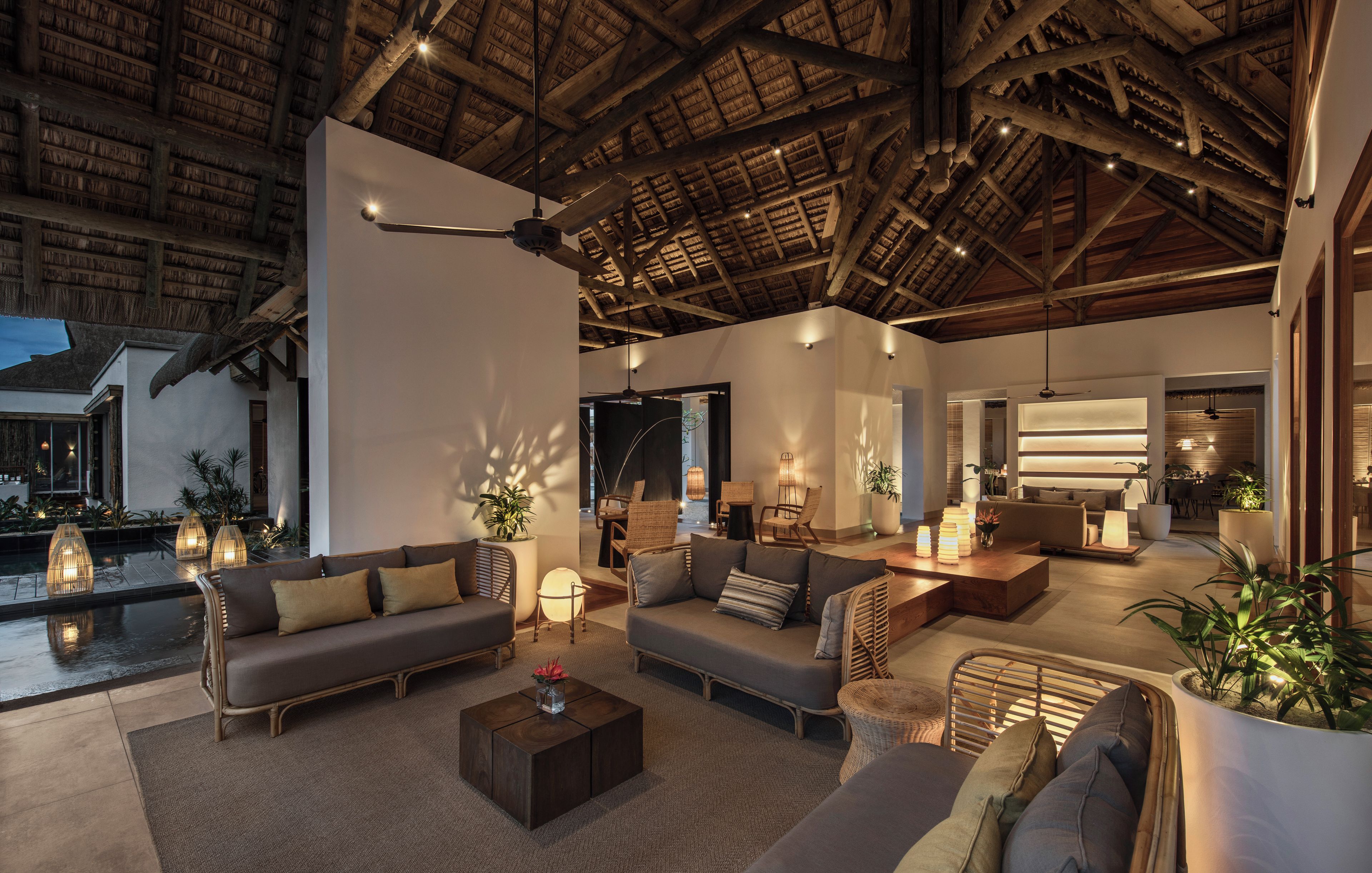 A spacious indoor area with a high ceiling, wooden beams, and a pool.